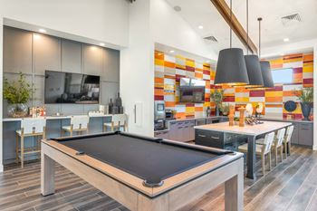a game room with a pool table and a kitchen with a tvat Weylyn Luxury Apartments, Laveen, AZ